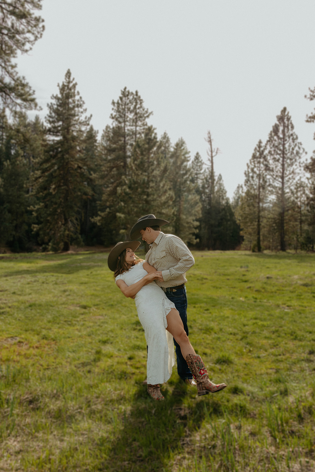 Madalyn and Hunter laughing together in a sunlit meadow