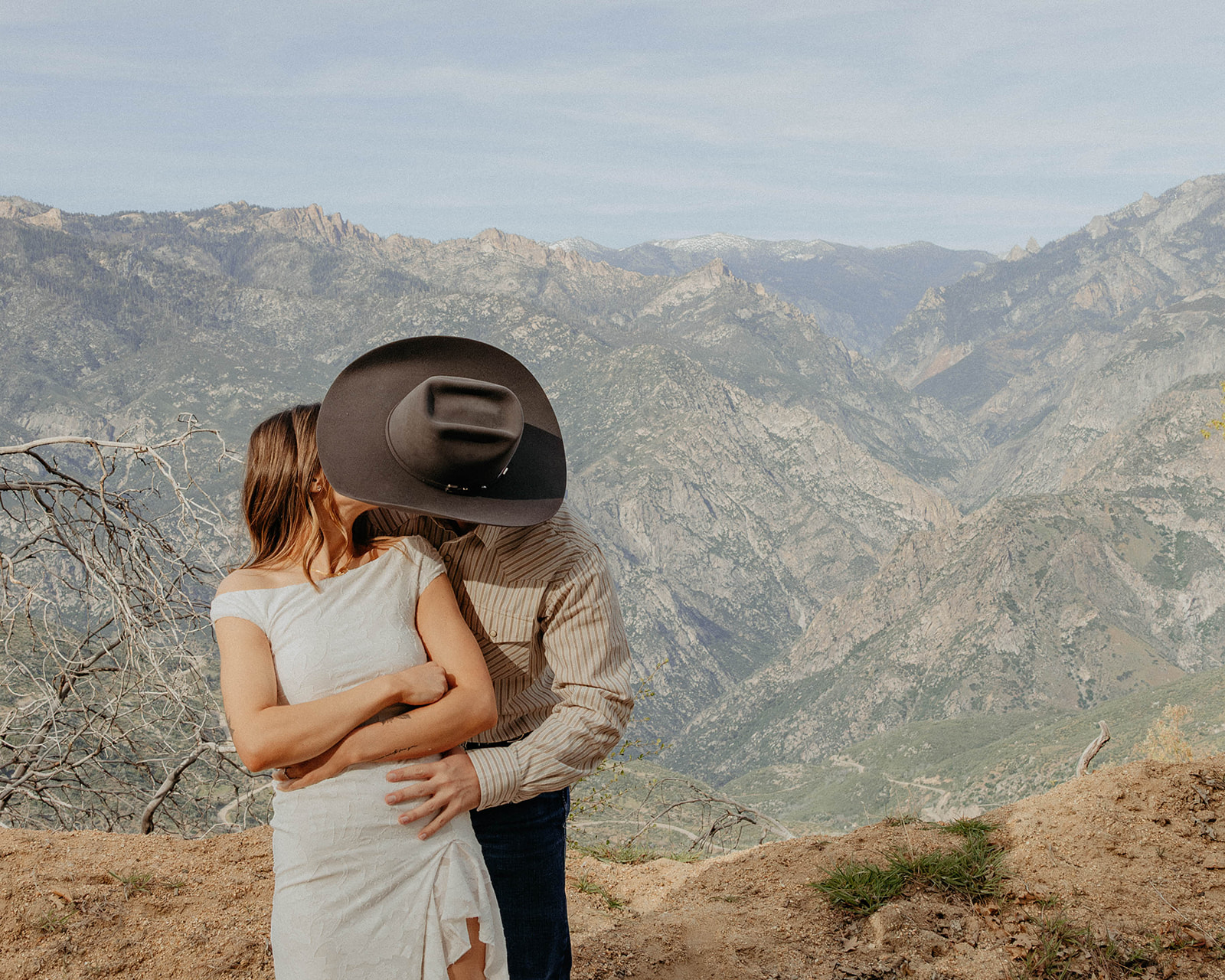 Madalyn and Hunter embracing with the mountains behind them
