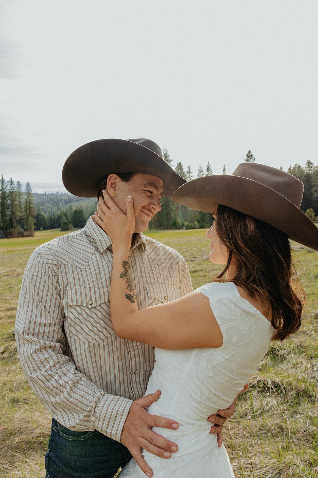 Madalyn and Hunter smiling at each other in the meadow